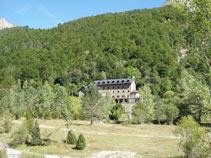 Al otro lado destaca un frondoso bosque y el edificio del Parador del Monte Perdido.