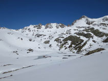 El pequeño lago de Siscar, helado y lleno de nieve durante la temporada de invierno.