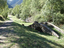 El puente con la escultura al lado del camino.