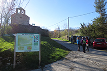 Entrada de Puigsac con la iglesia a mano izquierda (panel explicativo y palo señalizador).